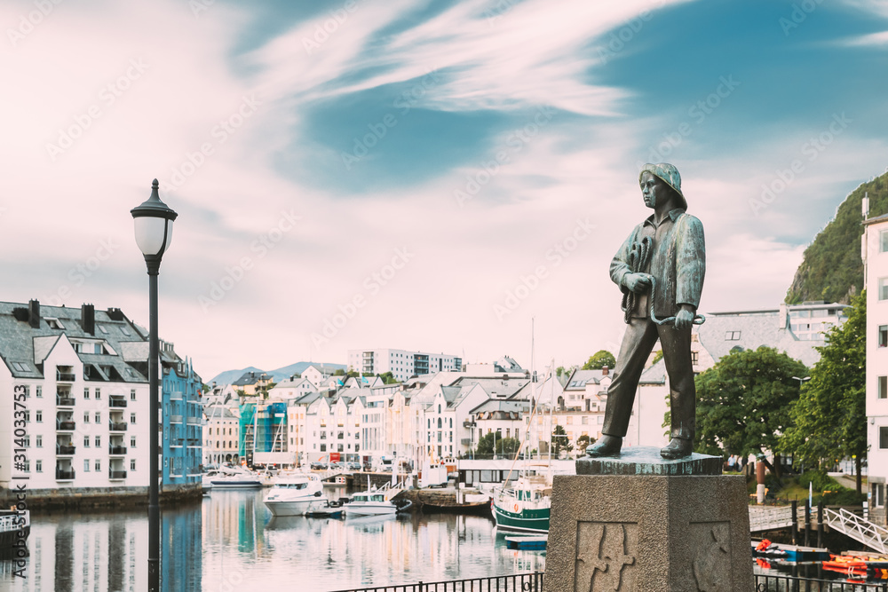 Alesund, Norway. Statue Of Young Sailor-fisher Boy On Brosundet Canal. Old Wooden Houses In Summer Day