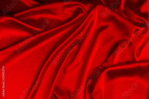 Red silk or satin luxury fabric texture can use as abstract background. Top view.