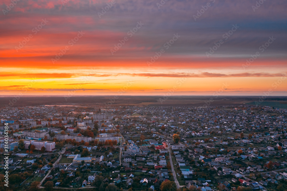 Fototapeta premium Dobrush, Gomel Region, Belarus. Aerial View Of Dobrush Cityscape Skyline In Autumn Evening. Residential District And River During Sunset. Bird's-eye View