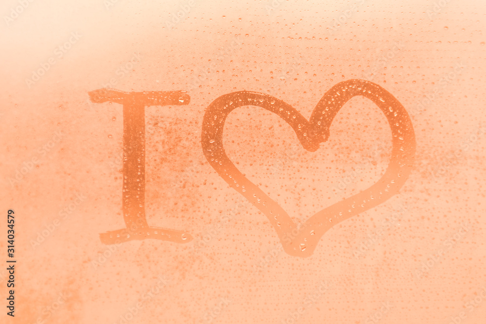 The romantic inscription I love you on the orange or pink evening or morning window glass with drops The romantic inscription I love you on the orange or pink evening or morning window glass with drops