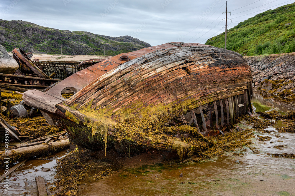 Φωτογραφία Russia, Arctic, Kola Peninsula, Barents Sea, Teriberka: Rusty abandoned fishing boat shipwreck at low tide near the historical fishing harbor of the old Russian settlement small fishing village