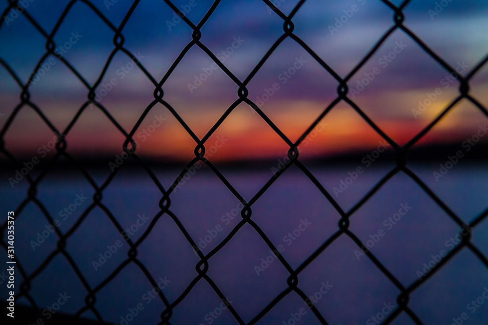 Fototapeta premium sunset through a fence
