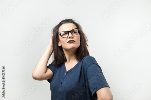 Image of excited young lady with glasses. Looking camera have an idea. Stands on a white background.