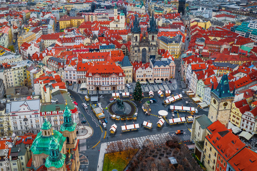 Prague, Czech Republic - Aerial drone view of the Christmas market on the Old Town Square at Christmas time with Old Town Hall tower, Church of our Lady before Tyn and traditional red rooftops