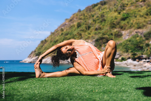 jana shirshasana on a rock early morning near the sea photo