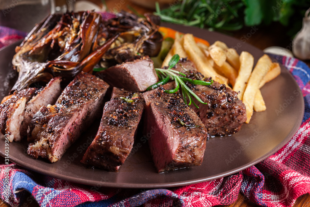 Slices of beef steak served with baked artichoke Slices of beef steak served with baked artichoke