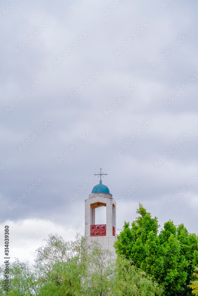 Bell Tower of a church rising above green trees