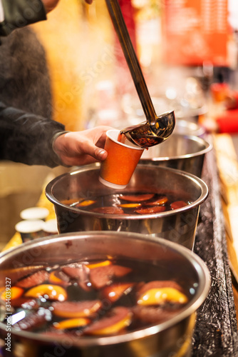 Hot mulled wine at the christmas market. Steam over cauldrons with hot wine. Street food. Outdoors. Closeup. Selective focus