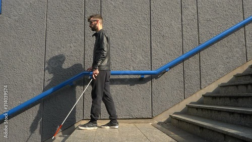 indipendent blind man going down stairs in the city photo