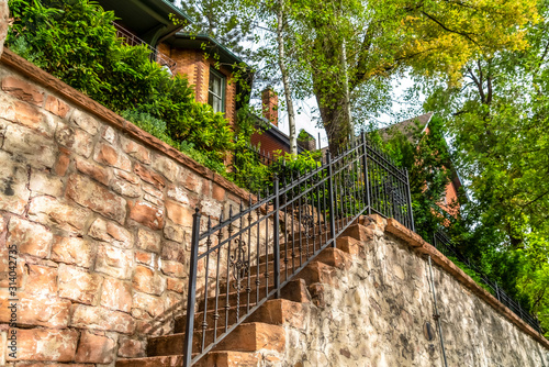 Staircase with stone treads and metal railing at the facade of a brick home photo