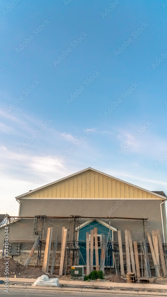 House exterior with construction materials against wall on blue sky background