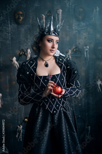 Foto Evil Queen in a black dress with a red apple in their hands