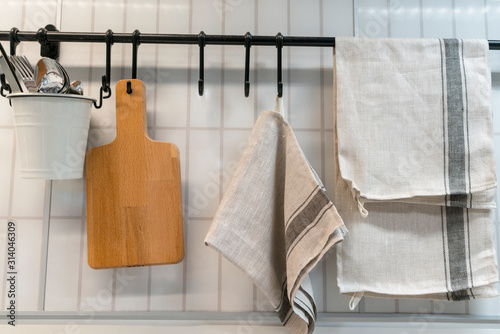 A kitchen towel and utensils are hanging on the wall. scandinavian cuisine