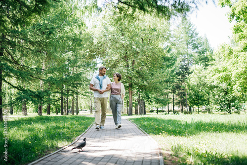 Middle-aged couple walking in the park together at the weekend.