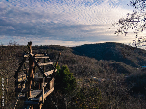 Tableau sur toile A treehouse made for a child against the backdrop of a mountain landscape and a cloudy sky