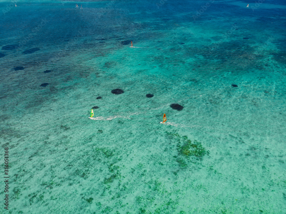 Kiter and windsurfer in tropical ocean at paradise Mauritius. Aerial view.
