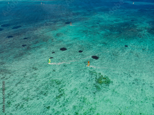 Kiter and windsurfer in tropical ocean at paradise Mauritius. Aerial view.