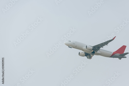 Airplane taking off with cloudy sky at background