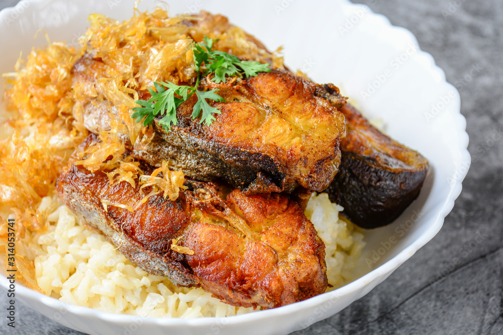 Deep fried sliced Pangasius fish with garlic, served with brown rice. Deep fried sliced Pangasius fish with garlic, served with brown rice.