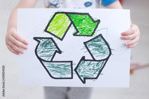 little boy holdf elt-tip pen drawing with recycling sign in the playroom. Ecology and environmental protection concept. selective focus