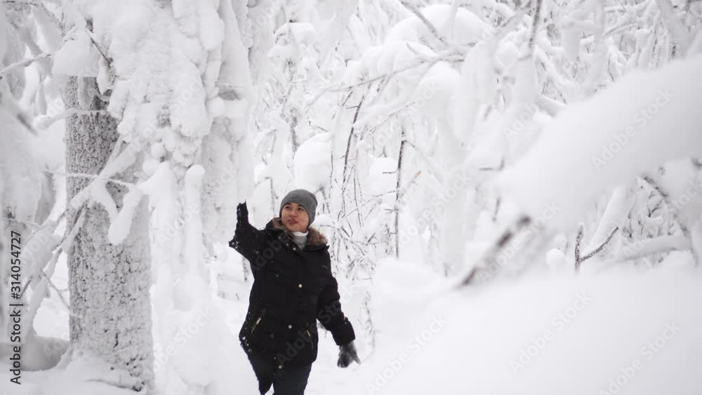 Beautiful young asian woman is walking in winter forest full of snow in cold weather. Getting lost in the woods Beautiful young asian woman is walking in winter forest full of snow in cold weather. Getting lost in the woods
