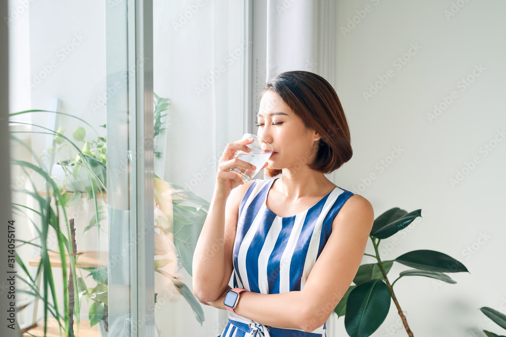 omen standing in front of windows and holding coffee cup in the morning omen standing in front of windows and holding coffee cup in the morning