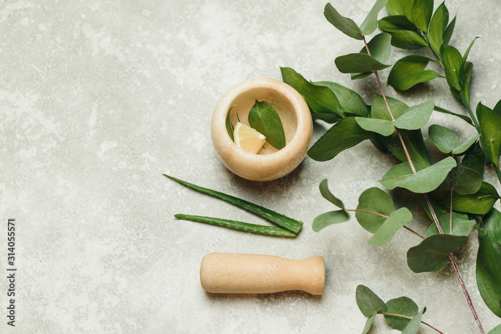 Flat lay composition with cosmetic products on grey background. Natural organic botanic, Natural skin care beauty products. The creation of natural cosmetics in a mortar of marble Flat lay composition with cosmetic products on grey background. Natural organic botanic, Natural skin care beauty products. The creation of natural cosmetics in a mortar of marble