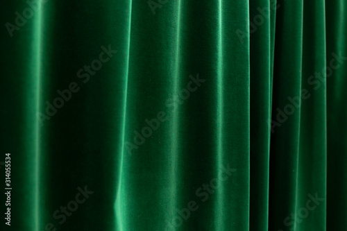 dark depp green curtains with soft folds - horizontal close up photo with selective focus. Perfect background