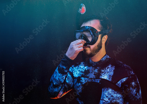 Scuba diver trying to equalize presure on the depth photo