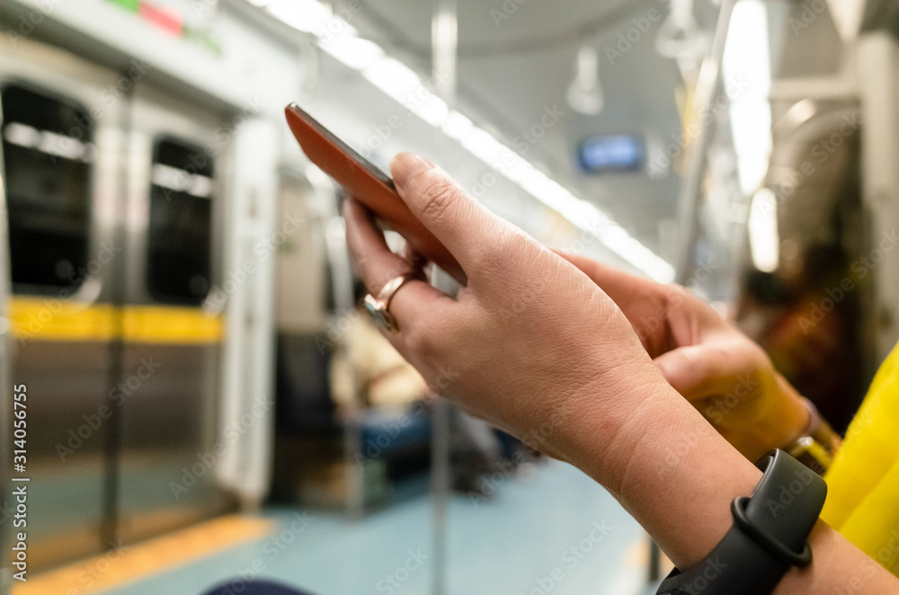 using smartphone at the MRT carriage
