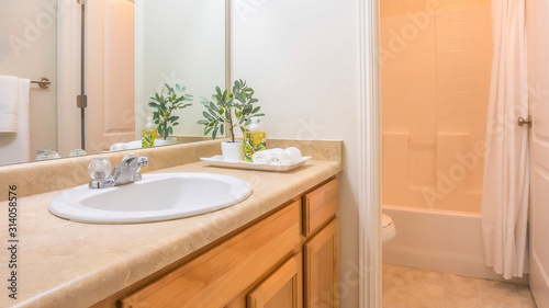 Pano Modern bathroom interior with white wall and view of bathtub toilet and vanity