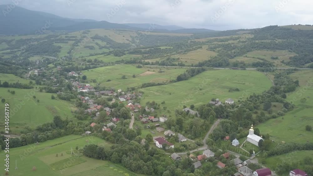 Ukrainian Carpathian mountains in the area of the pass. Latorka village in a picturesque valley among the hills from a bird's eye view.. Forested hills Ukrainian Carpathian mountains in the area of the pass. Latorka village in a picturesque valley among the hills from a bird's eye view.. Forested hills
