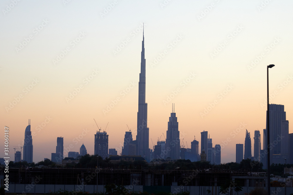 Dubai skyline with Burj Khalifa skyscraper at sunset, clear sky in United Arab Emirates