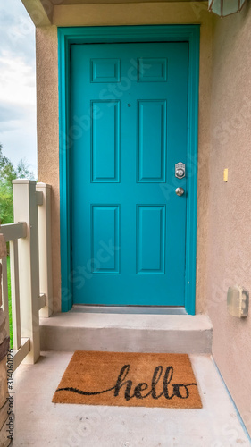 Vertical frame Close up of home entrance with blue green front door and concrete exterior wall