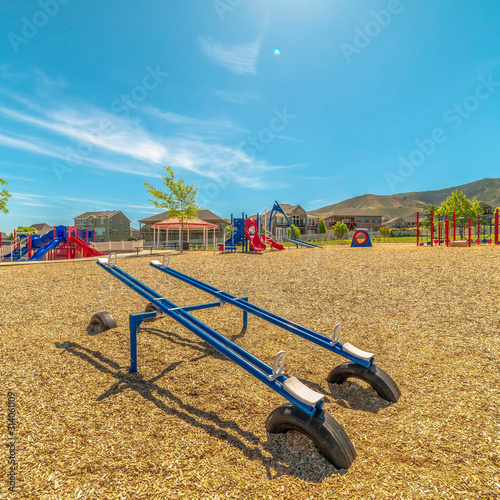 Bright blue see saw at a playground with Timpanogos Mountains and blue sky view