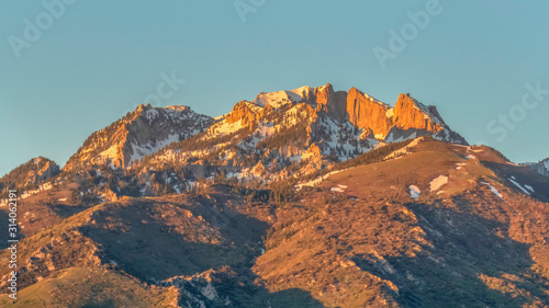 Pano frame Scenic view of a mountain peak with rugged slopes and dusted with snow