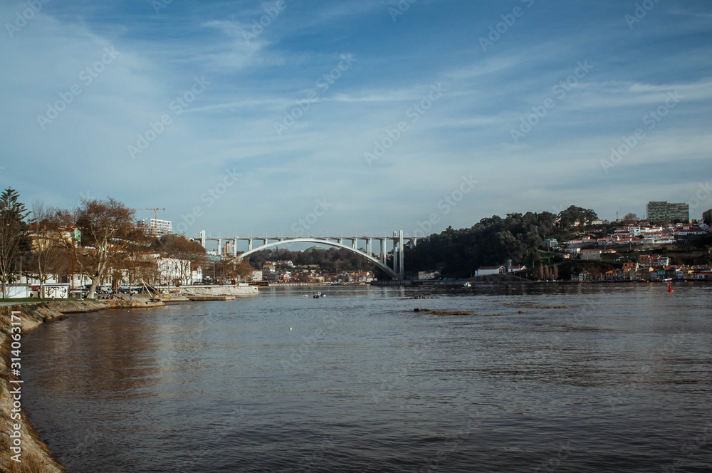 View of the river and the bridge, the path along the river. Beautiful city with the river Douro. Arrábida Bridge. Porto. Portugal.