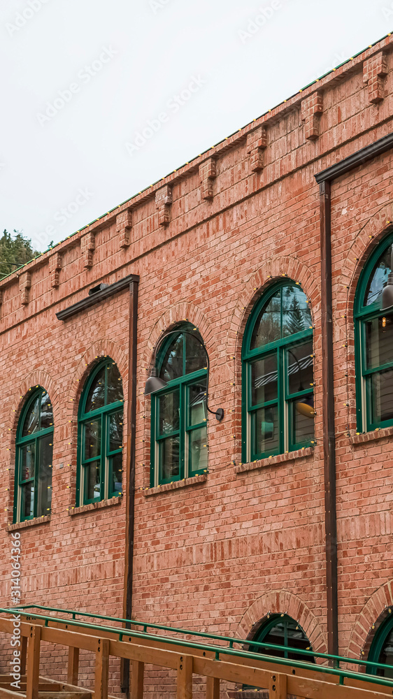 Vertical frame Restaurant exterior in Park City with red brick wall and green arched windows