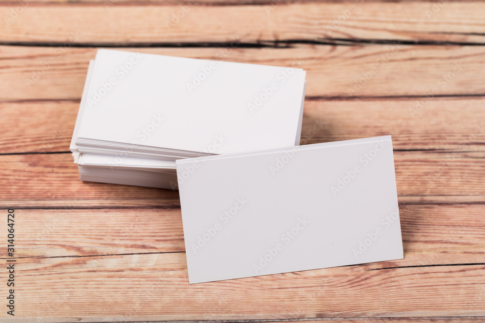 Photo of empty business cards on a light natural wooden background .. Template for identifier. Photo of empty business cards on a light natural wooden background .. Template for identifier.