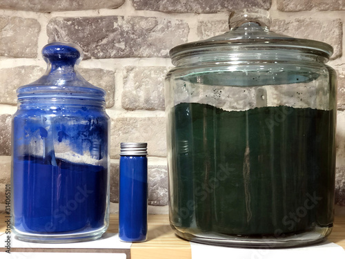 Green and blue colored recipients on a shelf