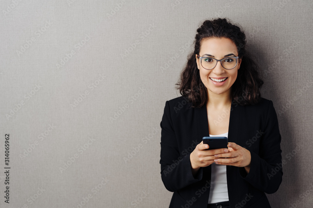 Pretty vivacious young woman holding her mobile Pretty vivacious young woman holding her mobile