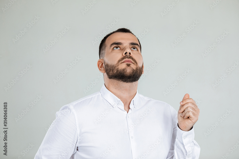 doubtful bearded man thinking about something on gray background. doubtful bearded man thinking about something on gray background.