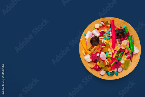 colored candies plate on dark blue background