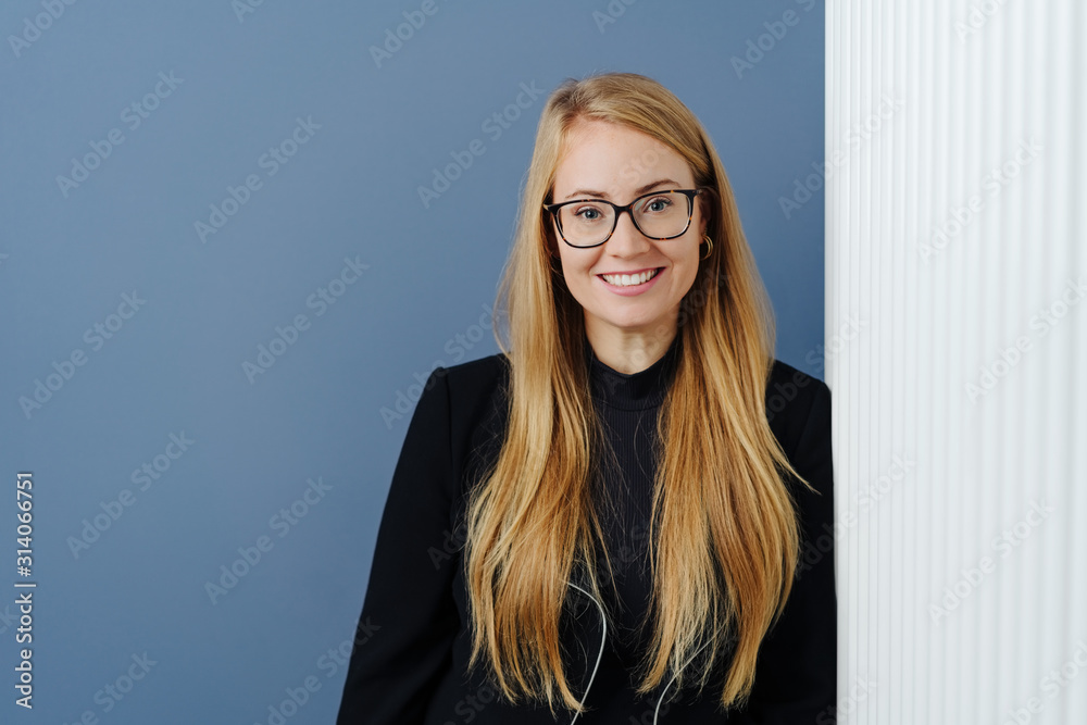 Relaxed smart young woman leaning against a wall
