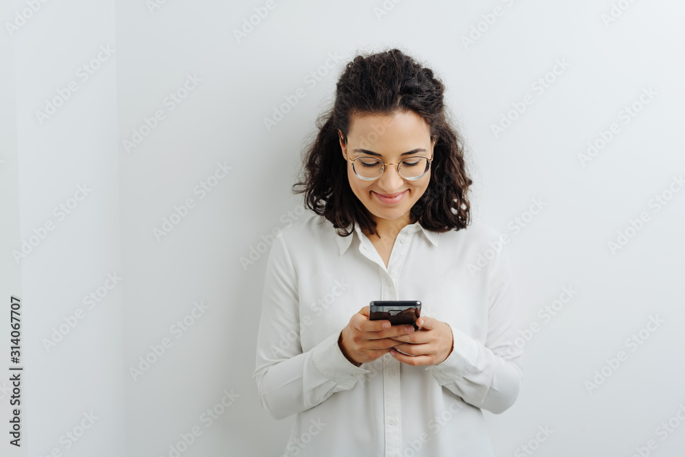 Young woman texting a message to a friend Young woman texting a message to a friend