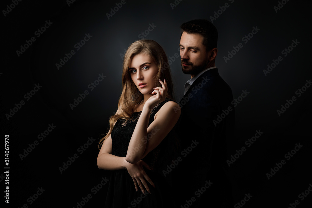 elegant couple on black background. handsome man and beautiful woman in black dress elegant couple on black background. handsome man and beautiful woman in black dress
