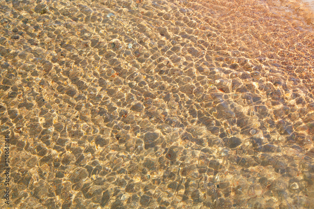 Clear water texture in blue. Background of the ocean and the sea backlit by the sun. Natural water Clear water texture in blue. Background of the ocean and the sea backlit by the sun. Natural water
