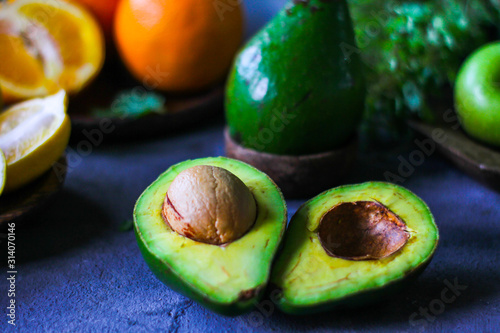 Photo of ripe organic avocado on dark background. Wooden table. Nutritious Fruit. Healthy food concept. Tropical vegetable. Green fruit. Image.