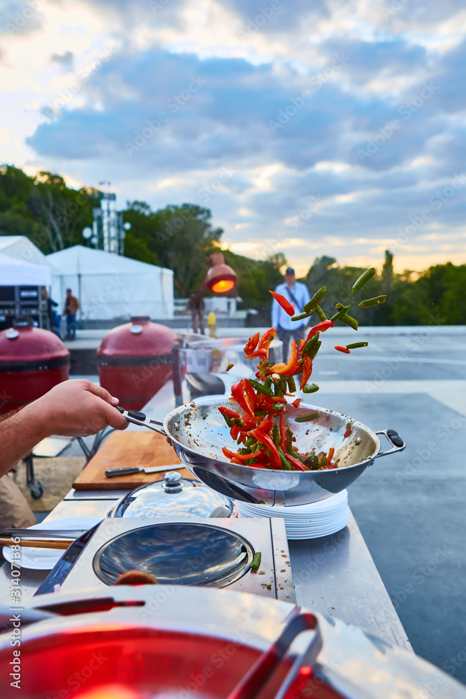 Obraz premium chef tossing vegetables in a wok