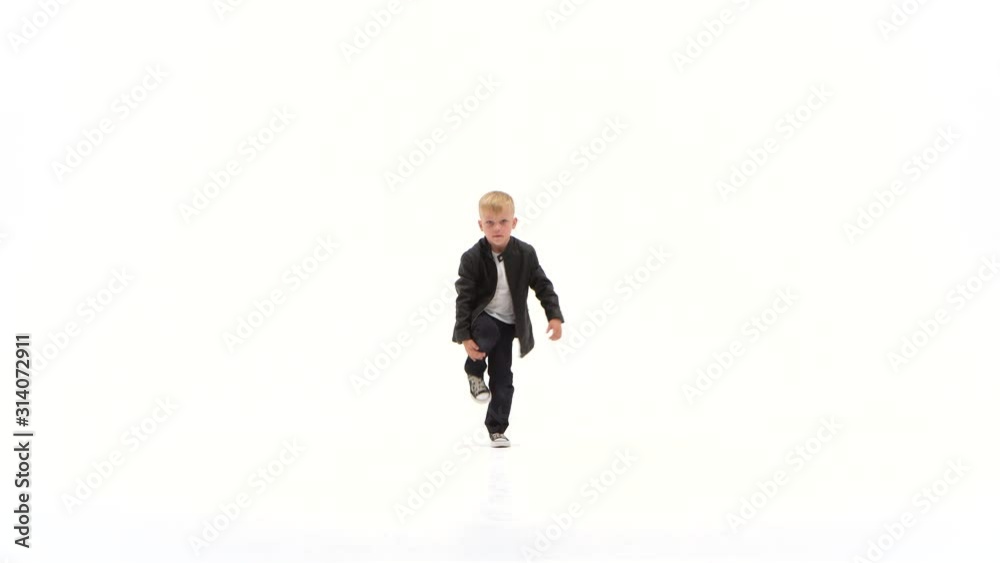 Little boy is dancing a modern dance on the white background in black leather jackets and jeans Little boy is dancing a modern dance on the white background in black leather jackets and jeans